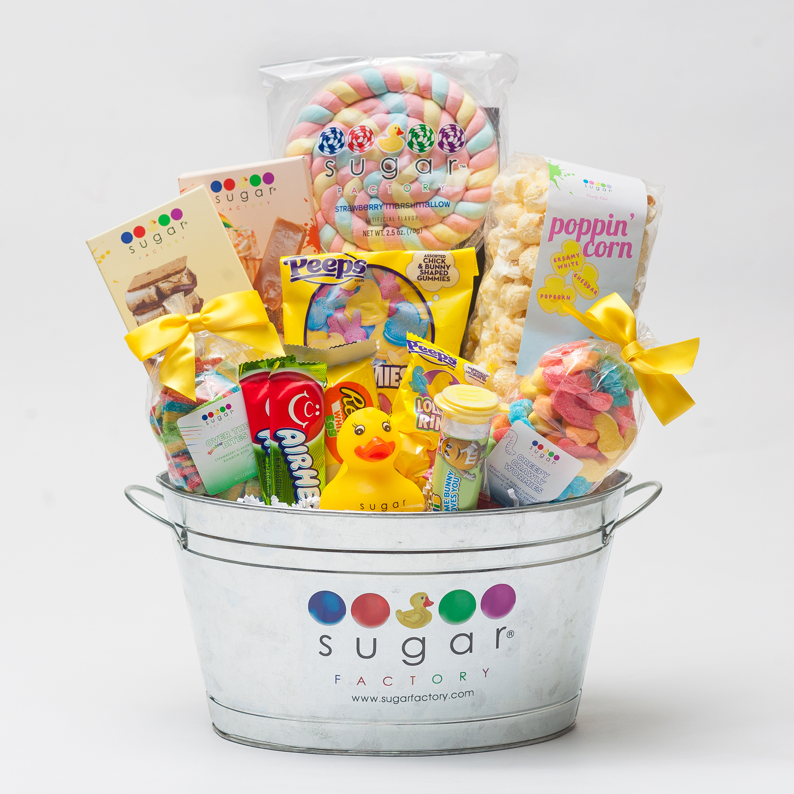 A photo of a bucket that says Sugar Factory and filled with candy