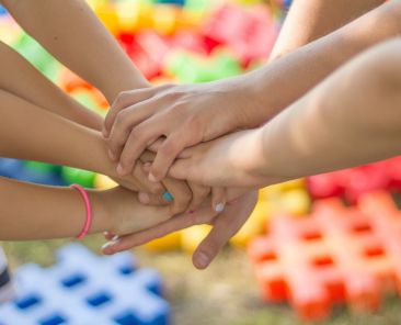 A photo of a bunch of hands holding each other
