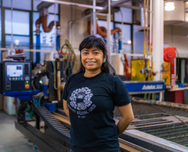 A photo of a woman smiling with equipment behind her