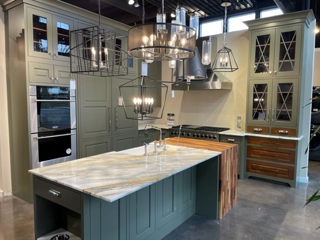 A photo of a kitchen with earth tones of light greens and brown