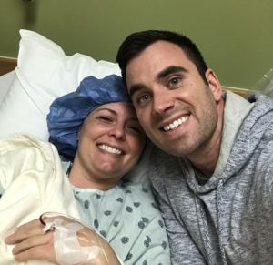 A photo of a woman in a hospital bed with her husband