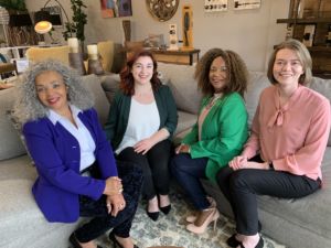 A photo of four women sitting on a couch