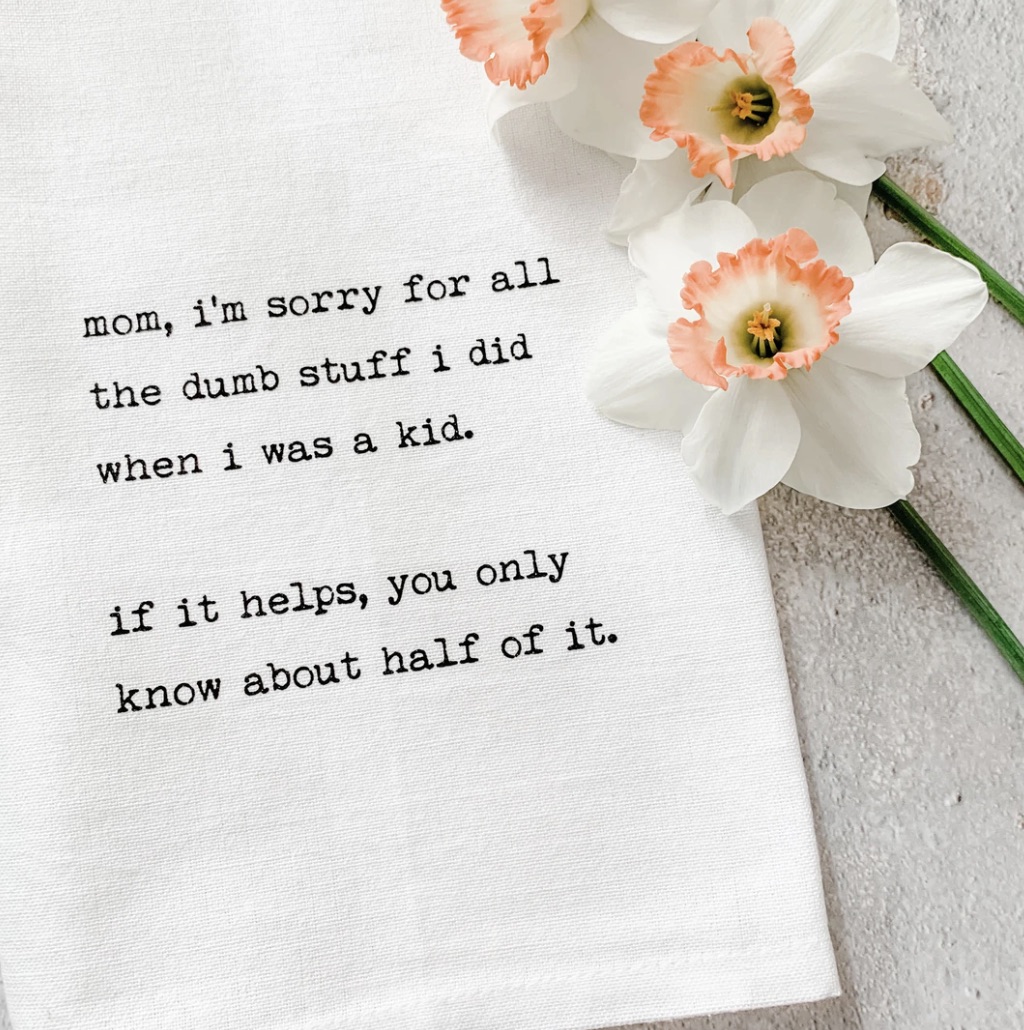 A photo of a tea towel that reads "mom, i'm sorry for all the dumb stuff i did when i was a kid. if it helps, you only know the half of it."
