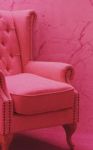 A photo of a pink upholstered chair