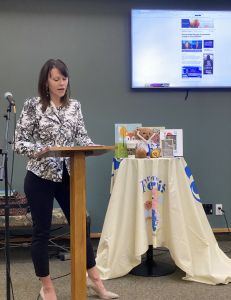 A photo of Tess Kossow speaking at a podium