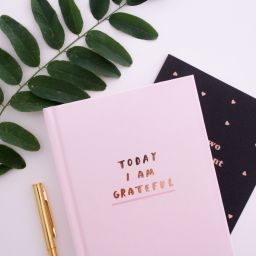 A photo of a journal book that says "Today I Am Grateful"