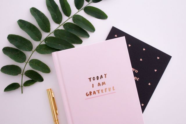 A photo of a journal book that says "Today I Am Grateful"