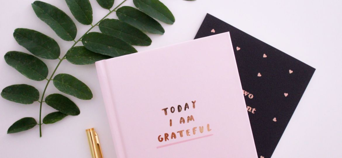 A photo of a journal book that says "Today I Am Grateful"