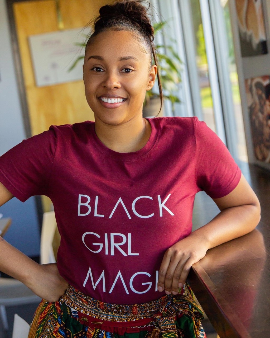 A photo of a woman wearing a t-shirt that says Black Girl Magic