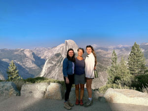 A photo of a woman and two daughters with the mountains behind them
