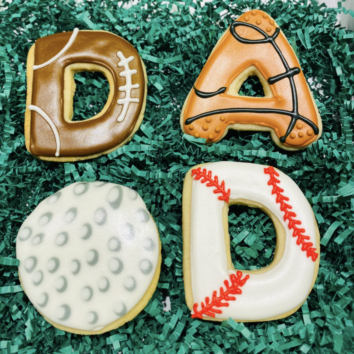 cookies that have football, baseball, and basketball designs on them that spell out the word dad