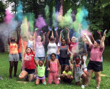 Children of Riley throwing colored powder during Camp Independence at Camp Riley