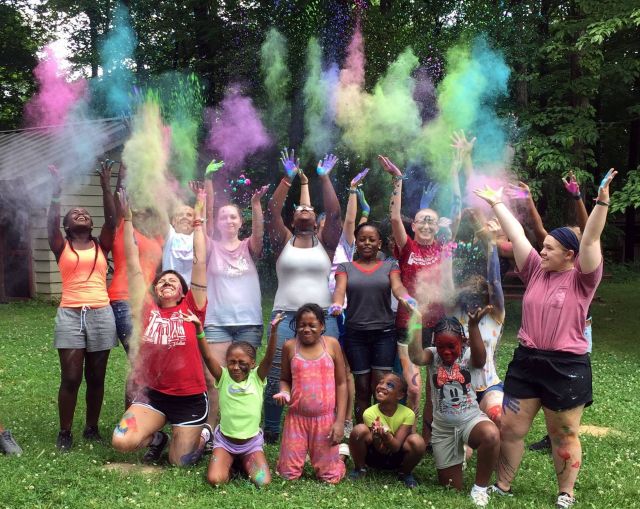 Children of Riley throwing colored powder during Camp Independence at Camp Riley