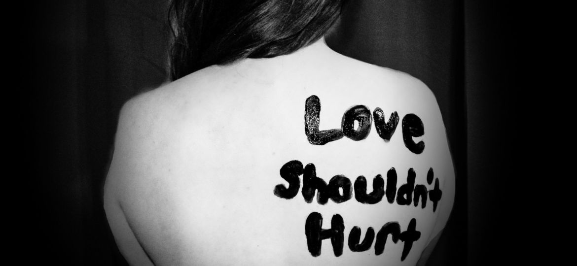 A woman with love shouldn't hurt written on her back