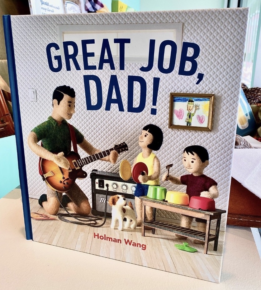 a children's book that has a dad playing the guitar and two little kids playing other instruments on the cover