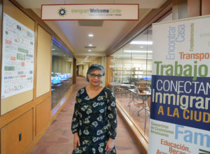Gurinder Kaur standing in front of an immigrant welcome center