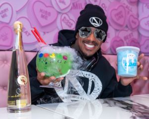 A photo of Nick Cannon holding sugar factory glasses