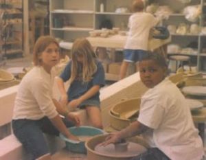young children making pottery at art camp 