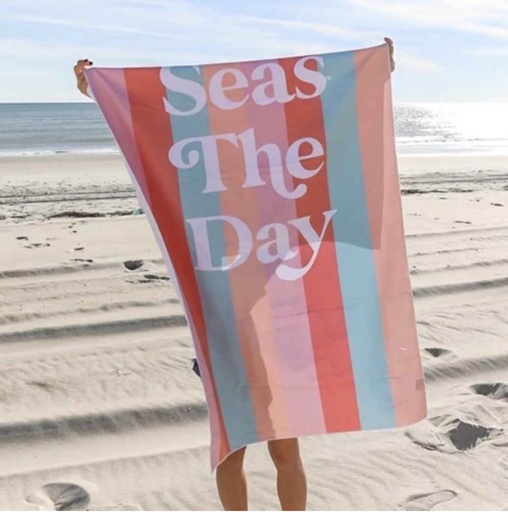 A beach towel that says seas the day