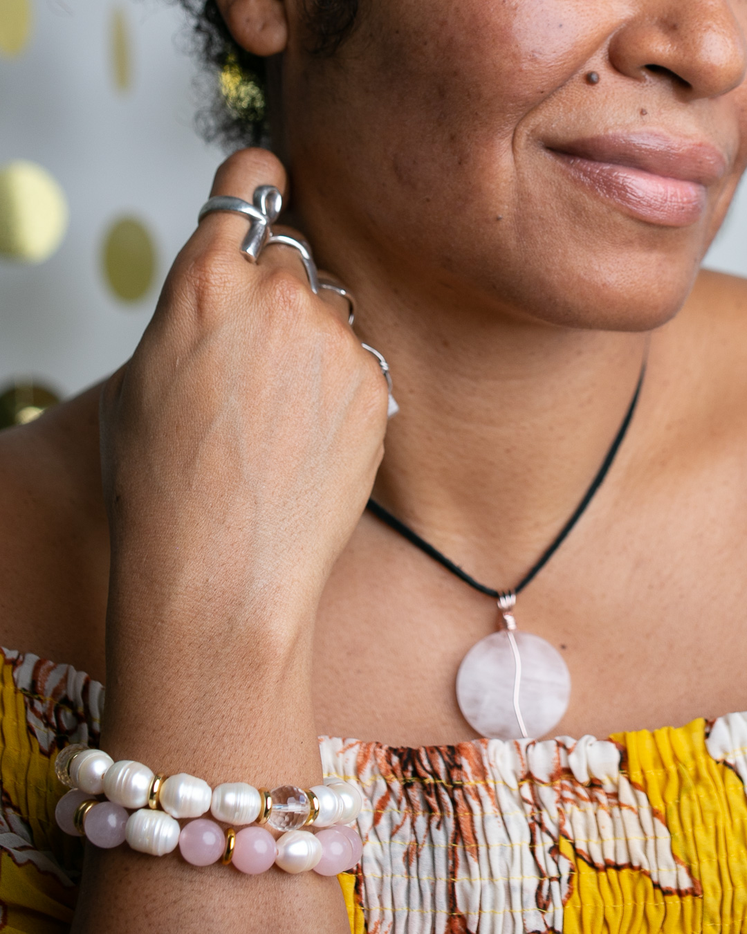 black woman wearing stone necklace and two stone bracelets