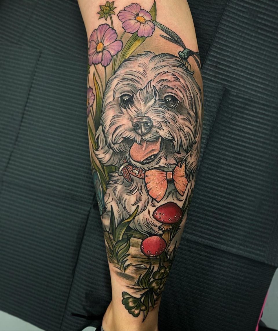 a tattoo of a grey dog with purple orange and red flowers around it