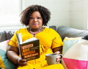 Woman in yellow dress with coffee cup and book 