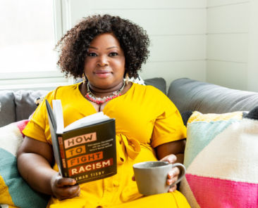Woman in yellow dress with coffee cup and book
