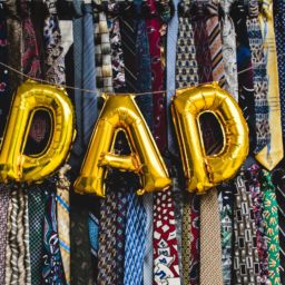 A dad shaped balloon in front of two rows of neckties