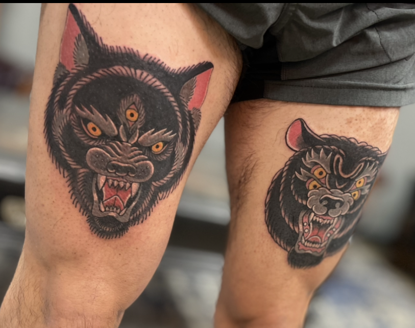 tattoo of a black angry wolf with three yellow eyes