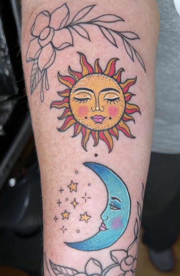 a tattoo of a yellow and orange sun with bright cheeks soft smiling and a bright blue crescent moon with stars