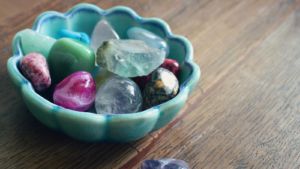 different colored Reiki crystals in a light blue porcelain bowl