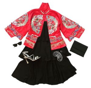 black sleeveless dress with red kimono and silver heels and silver hoops and black clutch bag on white backdrop