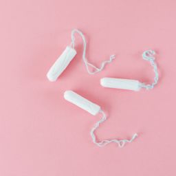 Three tampons on a pink background