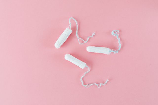 Three tampons on a pink background