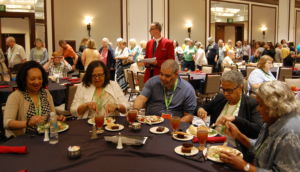photo of people of many nationalities sitting at a table at a Previous Midwestern Roots Conference