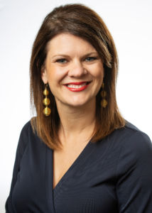a photo of jill robisch from the national bank of Indianapolis smiling with teeth wearing a black blouse in front of a white background