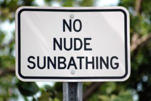 a picture of a sign that says "no nude sunbathing"