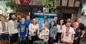 a photo of members from the Ukrainian Society of Indiana celebrating Ukrainian embroidered shirt day at a bar