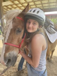 A photo of Emily Nelson with a horse