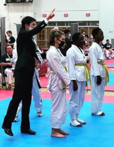 a photo of Emily Nelson participating in Tae Kwon Do with two other students