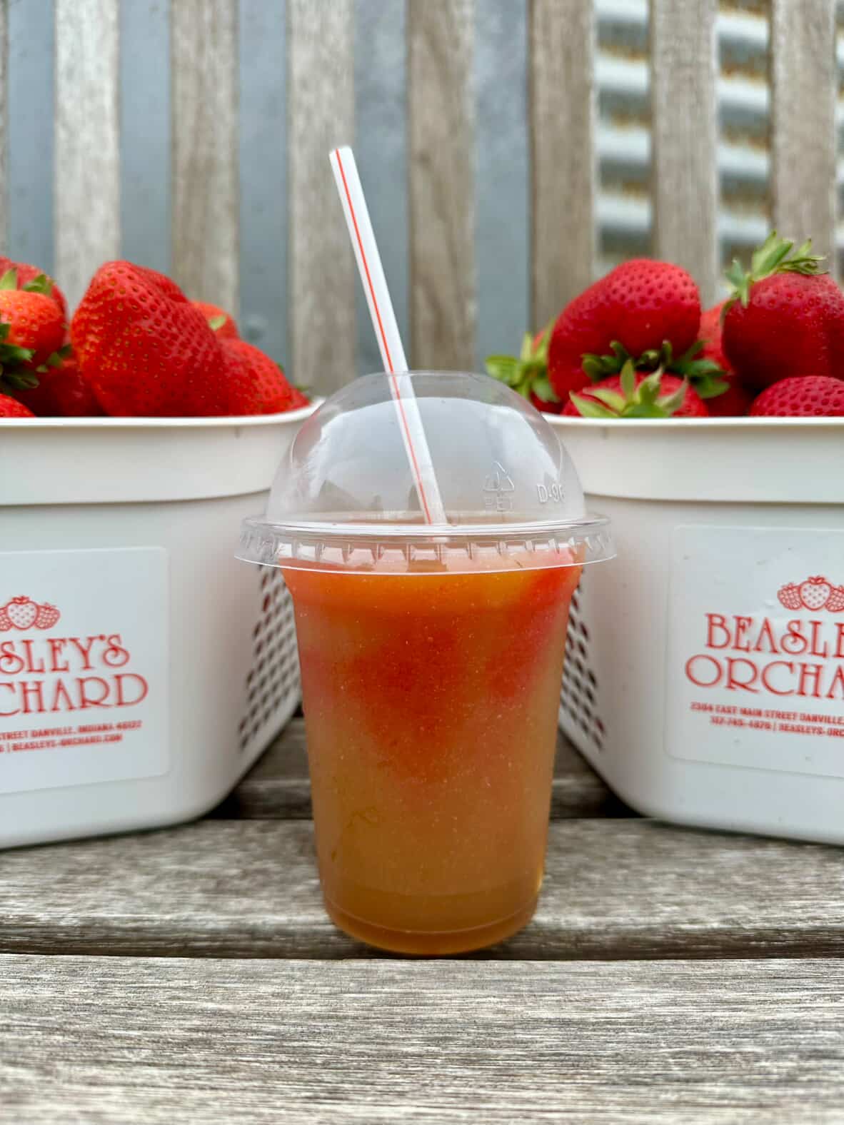 Strawberry Slushie in between two buckets of strawberries that read Beasley's Orchard