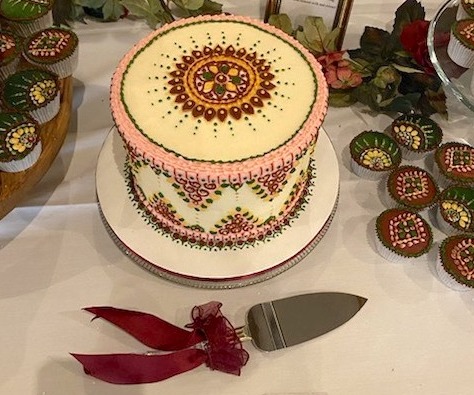A round cake surrounded by cupcakes made by Naleni Amarnath