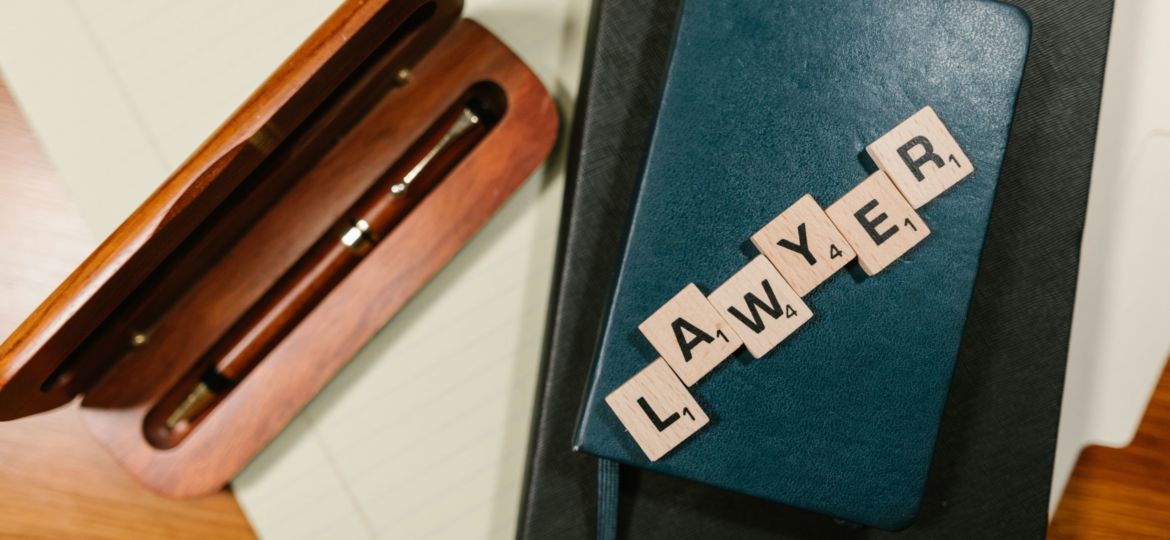 Scrabble tiles spelling out "LAWYER"