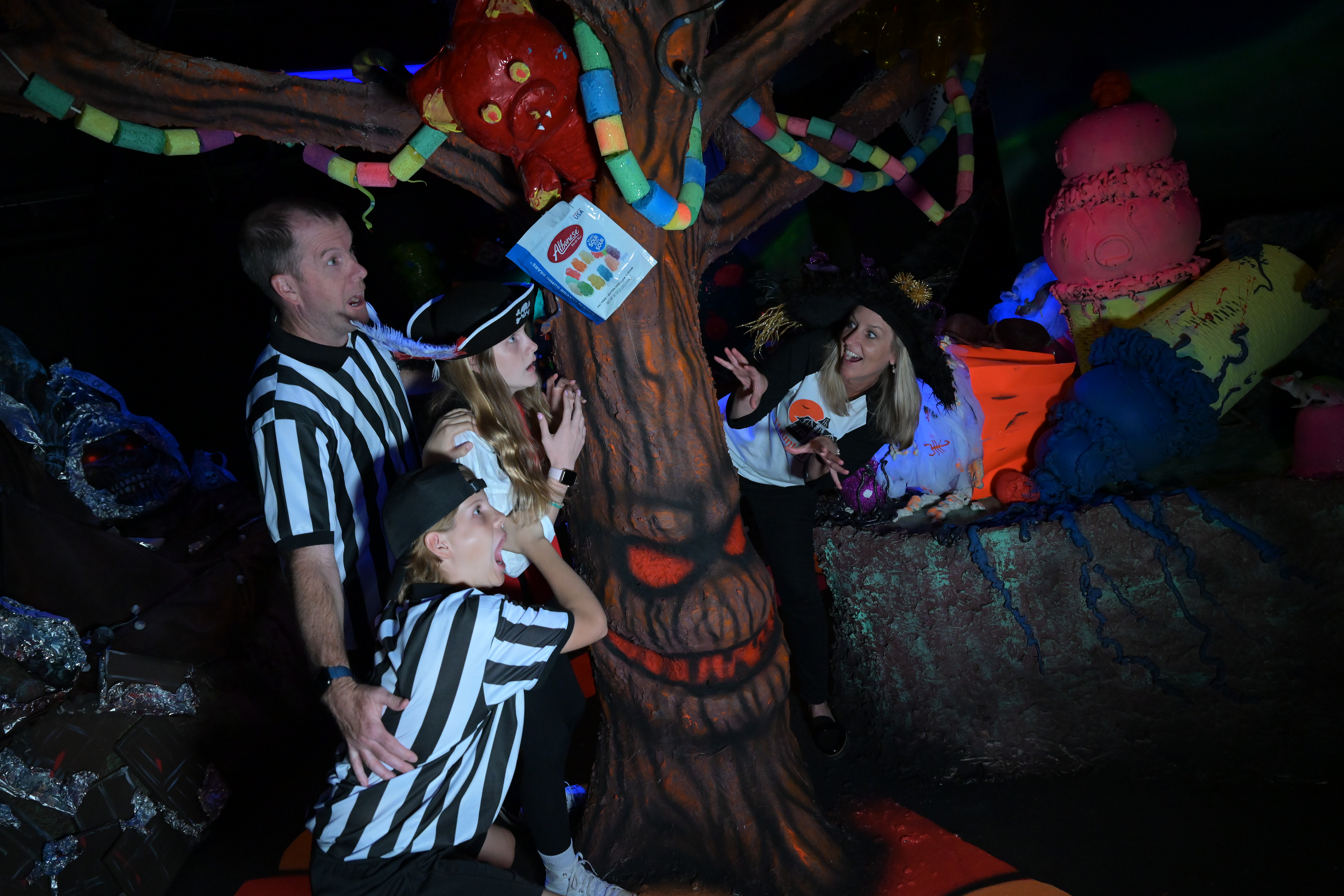 A woman scaring a family at a Halloween haunted house