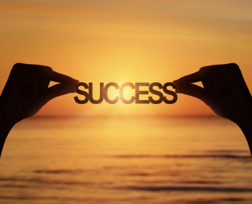 Hands holding up a success banner