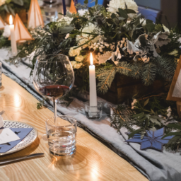 table set for a festive feast with candles and greenery