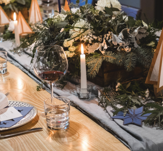 table set for a festive feast with candles and greenery