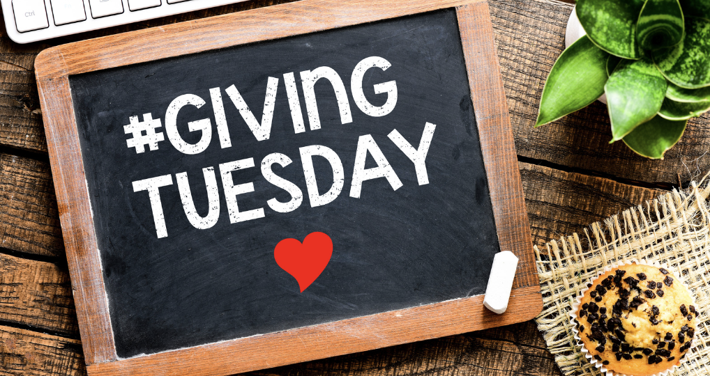 Chalk board reading "giving tuesday" with a heart drawn on it