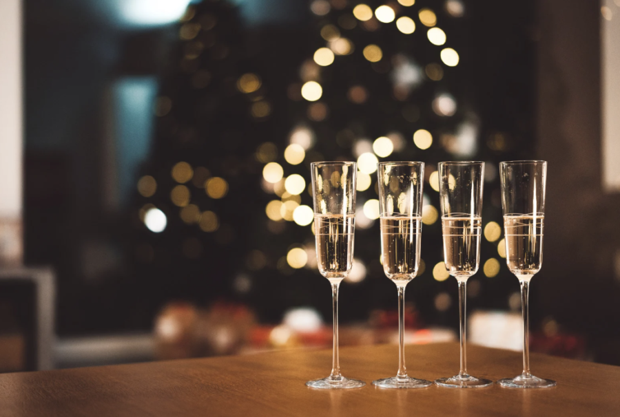 Four glasses of champagne on a table at a holiday party