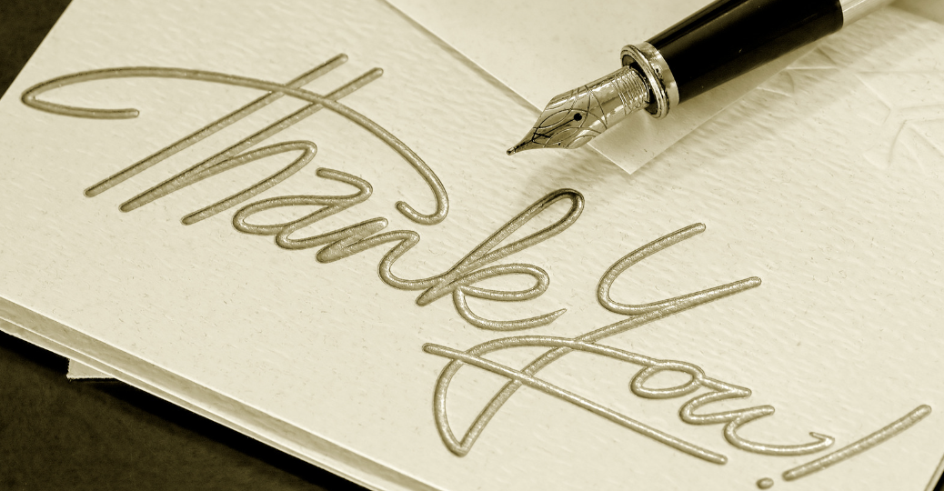 card reading "thank you" with a fountain pen resting on it
